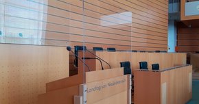 Eine Sicherheitsmaßnahme ist die Anbringung von Plexiglas vor dem Rednerpult sowie dem Vorsitz
