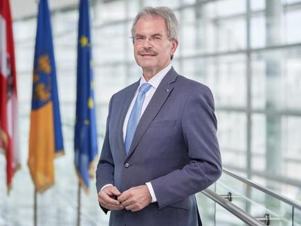 Präsident Karl Wilfing im NÖ Landtag; im Hintergrund die Fahnen Österreichs, Niederösterreichs und der EU