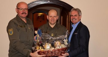 Präsident Wilfing überreicht zwei Offizieren einen Geschenkskorb