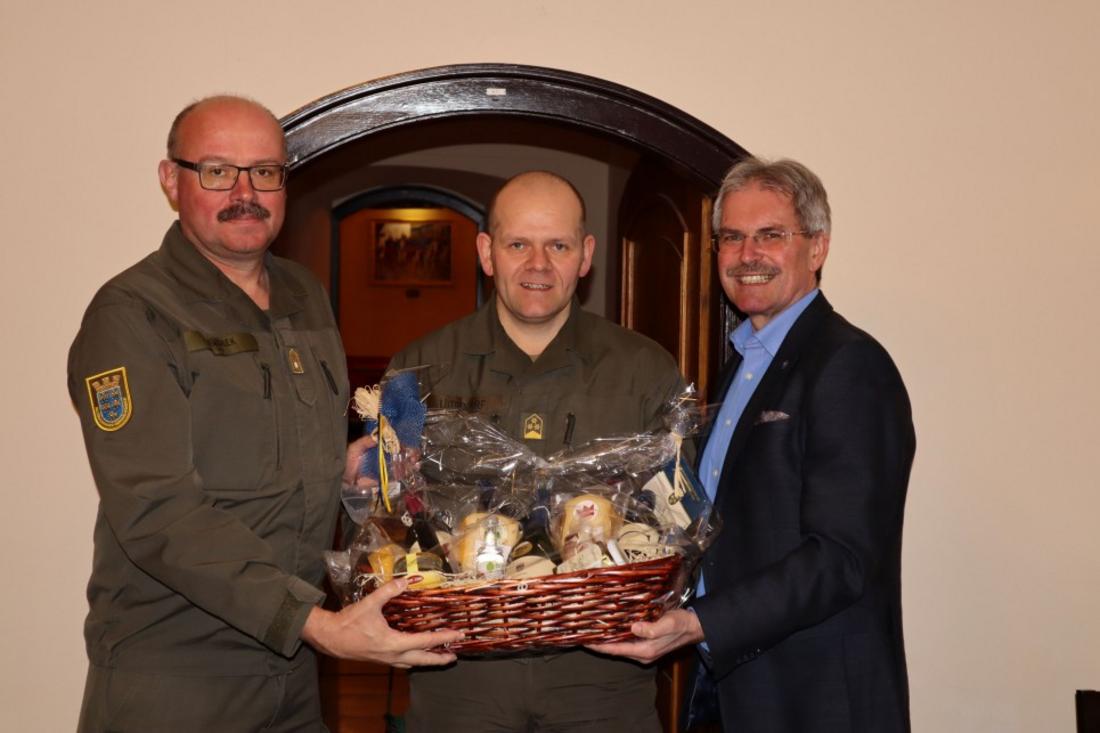 Präsident Wilfing überreicht zwei Offizieren einen Geschenkskorb