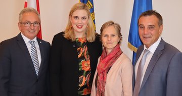 Großes Bild anzeigen Vier Politiker vor Fahnen.